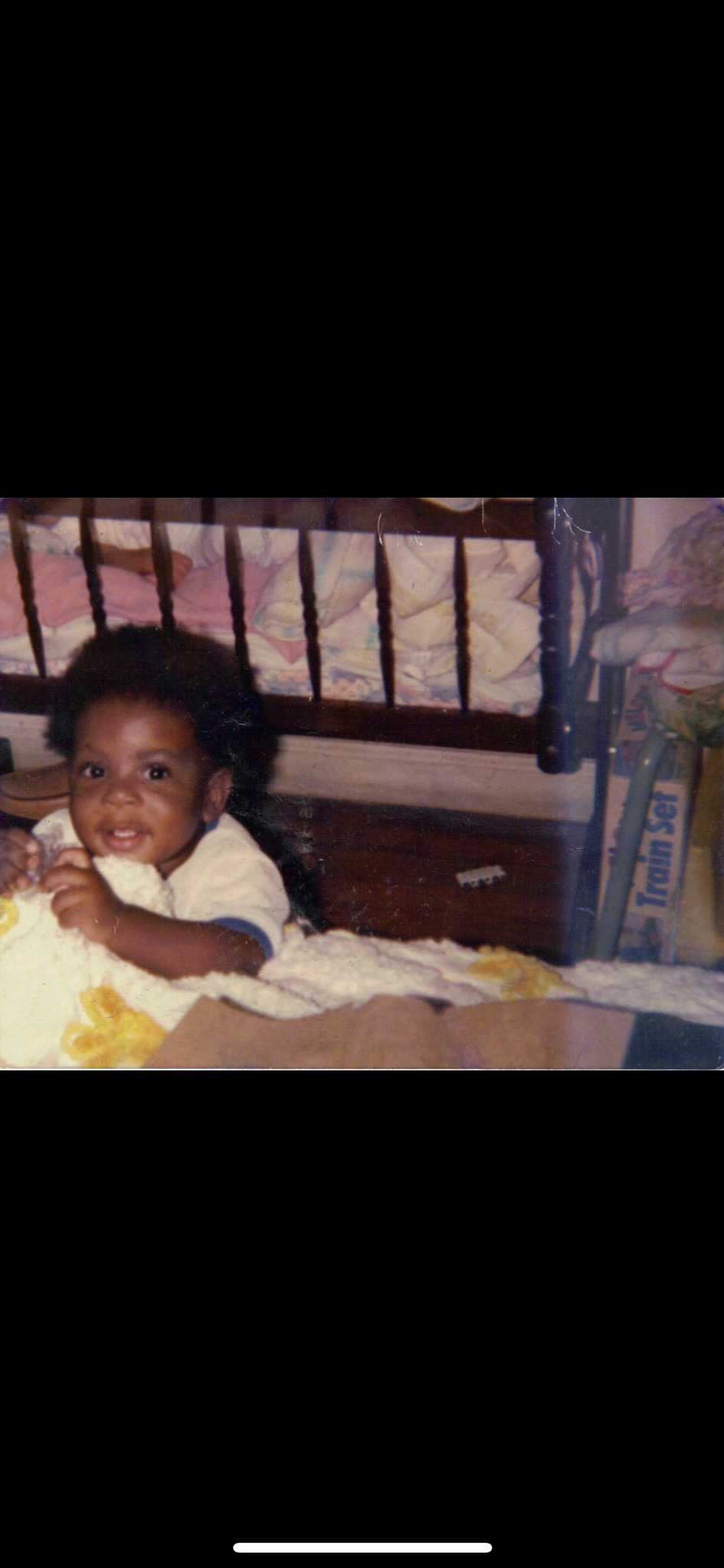 A childhood photo of Ant as a baby sitting on the floor